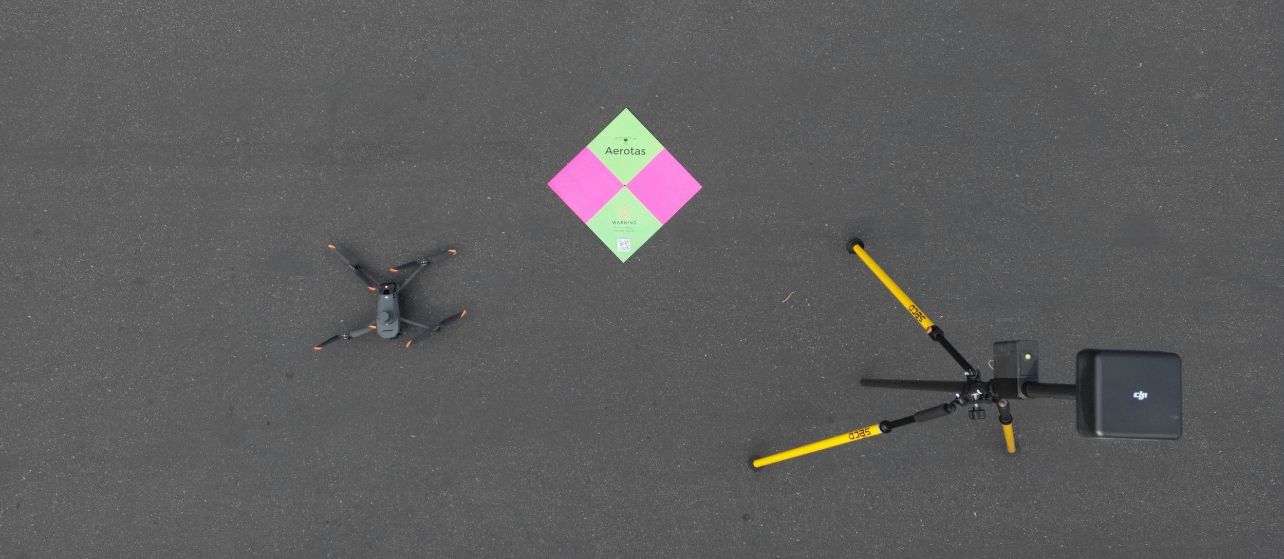 Compact survey drone staged on pavement for field deployment.