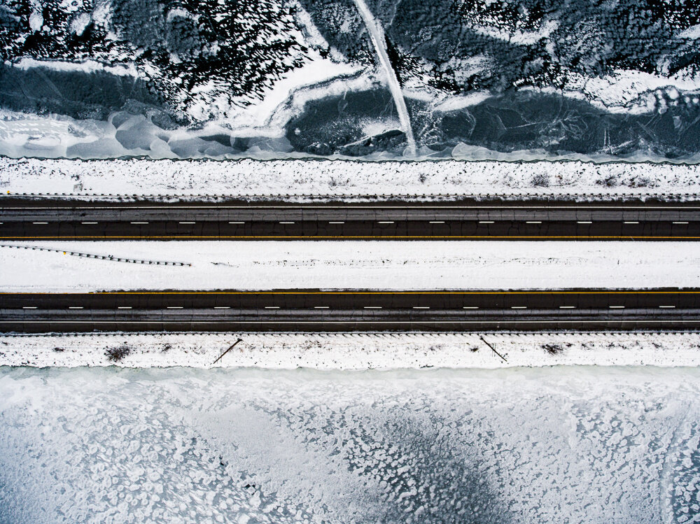 Snow-lined road captured for winter drone surveying conditions.